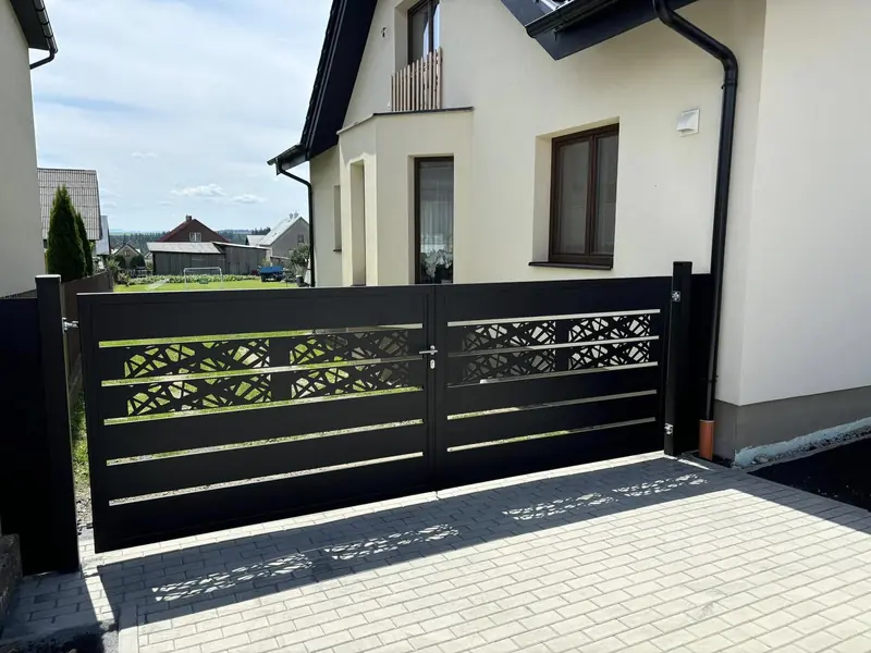 Hliníková krídlová brána v antracite s pásom DECOR pred rodinným domom